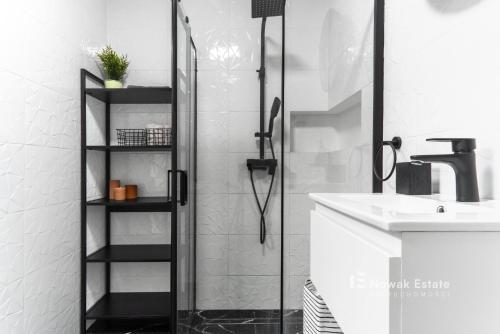 a bathroom with a shower and a sink at Promienistych 2 in Kraków