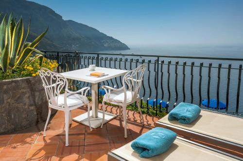a table and chairs on a balcony overlooking the ocean at Hotel Le Agavi in Positano