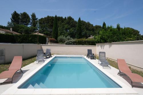 une piscine avec des chaises longues et une piscine dans l'établissement very pleasant villa with private swimming pool, in a residential area near the center of saint-rémy-de-provence - 8 people, à Saint-Rémy-de-Provence