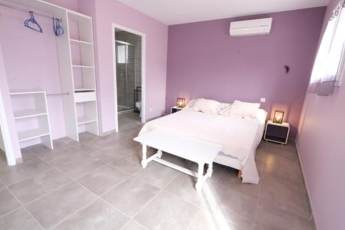- une chambre avec un lit blanc et des murs violets dans l'établissement very pleasant villa with private swimming pool, in a residential area near the center of saint-rémy-de-provence - 8 people, à Saint-Rémy-de-Provence