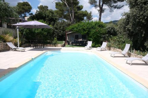 une piscine avec des chaises et un parasol dans l'établissement villa with pool and beautiful view in the luberon in pujet sur durance - 10, à Puget