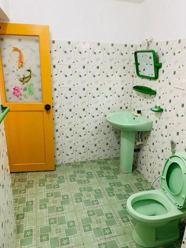 a bathroom with a green toilet and a sink at Tamaro Beach Resort in Hikkaduwa