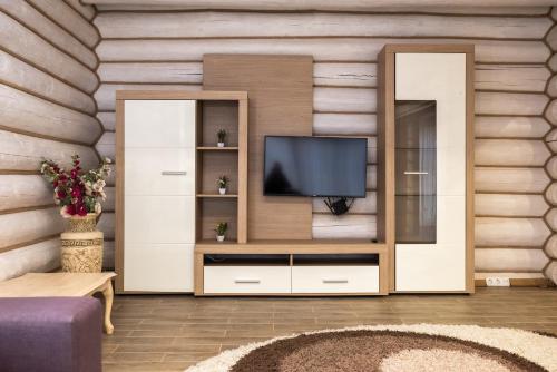 a living room with a entertainment center with a flat screen tv at Solva Resort Medical & SPA in Polyana