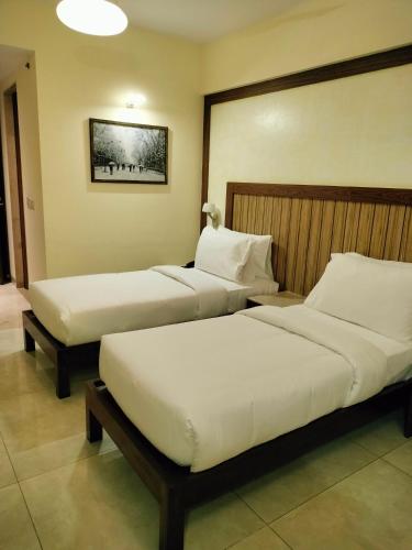 two beds in a hotel room with two bedsvisor at VITS Lonavala in Lonavala