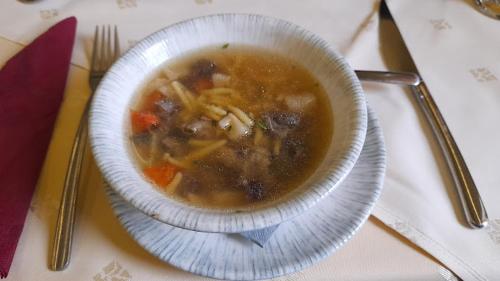 a bowl of soup on a plate on a table at Hegyi Panzió in Szilvásvárad