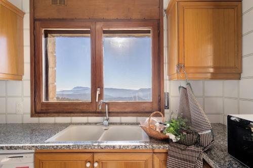 a kitchen with a sink and a window at Les Corts De Biosca in Castelltallat