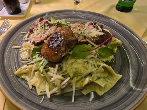 a plate of food with meat and salad on a table at Hegyi Panzió in Szilvásvárad