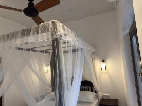 a bedroom with a canopy bed with white curtains at The Residence Bentota in Bentota