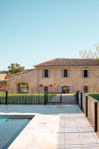 a brick house with a pool in front of it at Chambre tout confort à l'Héritier - au coeur du Tarn in Marzens