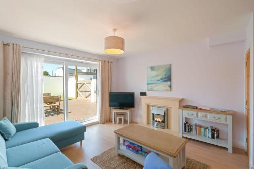 a living room with a blue couch and a tv at Townhouse Parking 1 Min Walk to Tolcarne Beach in Newquay