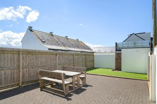 a patio with a table and a bench on a fence at Townhouse Parking 1 Min Walk to Tolcarne Beach in Newquay