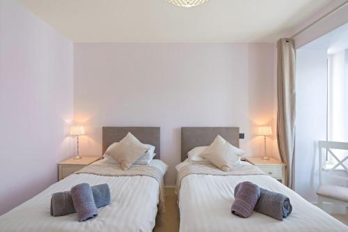 a bedroom with two beds with pillows on them at Townhouse Parking 1 Min Walk to Tolcarne Beach in Newquay