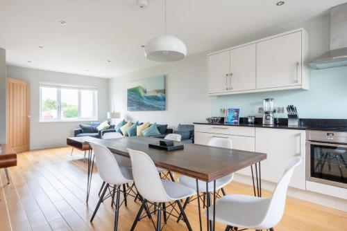 a kitchen and living room with a table and chairs at Modern House in St Agnes Parking & Garden in St. Agnes