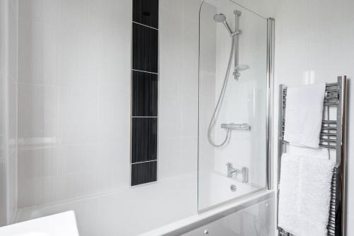 a bathroom with a shower and a sink with a mirror at Modern House in St Agnes Parking & Garden in St. Agnes