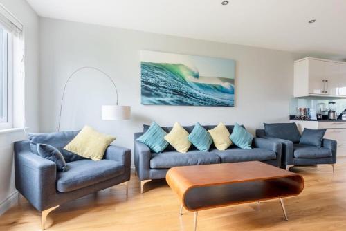a living room with two couches and a table at Modern House in St Agnes Parking & Garden in St. Agnes