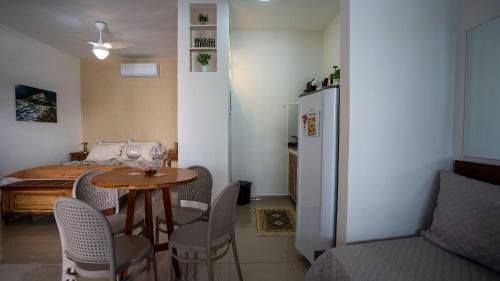 a kitchen with a table and chairs and a refrigerator at Acesso à Praia Ar Condicionado Conforto Garantido! in Saquarema