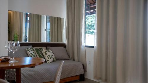 a living room with a couch and a table and a window at Acesso à Praia Ar Condicionado Conforto Garantido! in Saquarema