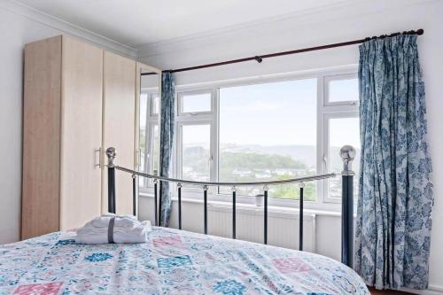 une chambre avec un lit et une grande fenêtre dans l'établissement Peaceful Home in Looe with Stunning Views, à Looe