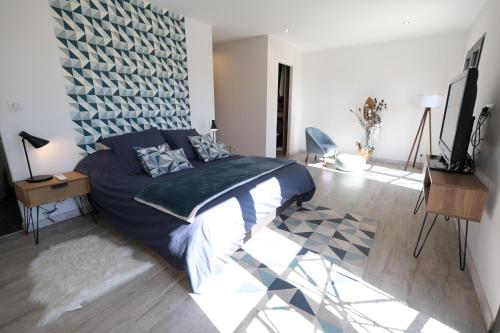 a bedroom with a bed with a blue comforter at very beautiful villa with private pool in the luberon enjoying a magnificent view of the durance valley, located in puget – 10 people. in Puget