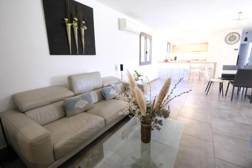 un salon avec un canapé et une salle à manger dans l'établissement very beautiful villa with private pool in the luberon enjoying a magnificent view of the durance valley, located in puget – 10 people., à Puget