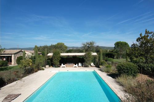 une image d'une piscine dans une cour dans l'établissement Air-conditioned Provençal farmhouse with private pool, view magnificent, located in Lagnes, close Isle S/Sorgue, 9 people, à Lagnes