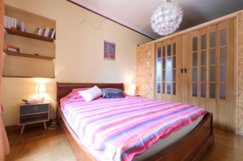 - une chambre avec un grand lit et une couverture rayée dans l'établissement pleasant holiday rental with swimming pool, in moulès, near arles, between the camargue and the alpilles – 6 people, à Arles