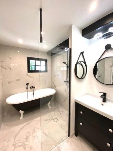 a bathroom with a tub and a sink and a shower at authentic provencal mas with pool, in the countryside of the village of sénas, close to the luberon and the alpilles, sleeps 8. in Sénas