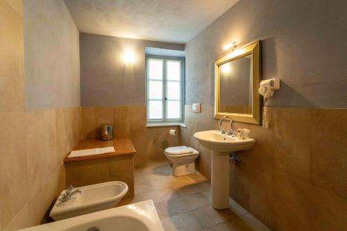 a bathroom with a sink and a toilet and a mirror at Foresteria del Castello di San Giorgio Canavese in San Giorgio Canavese