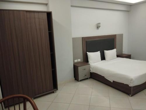 sypialnia z łóżkiem i dużą szafą w obiekcie Cecelia Resort w mieście Hurghada