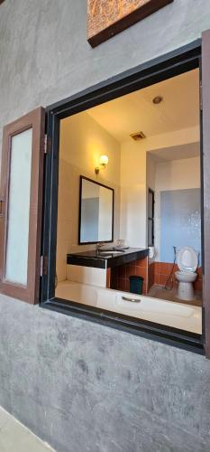 a bathroom with a mirror and a toilet at Velanon Phuket in Ban Lo Long