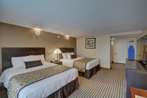 a hotel room with two beds and a kitchen at The Putney Inn in Putney