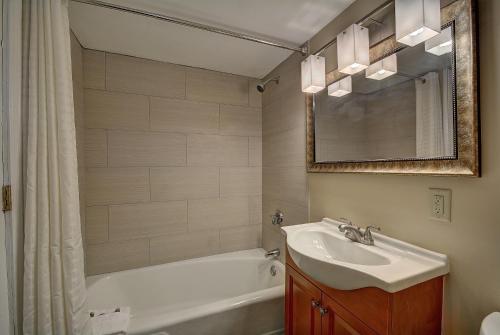 a bathroom with a sink and a tub and a mirror at The Putney Inn in Putney