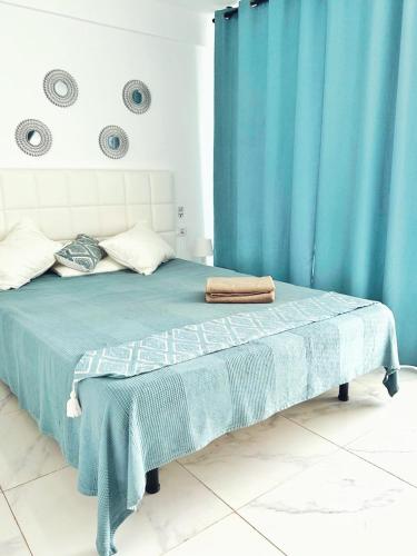 a bedroom with a bed with a blue curtain at Sunny Oceanview studio apartment Ponderosa in Costa Adeje in Playa de las Americas