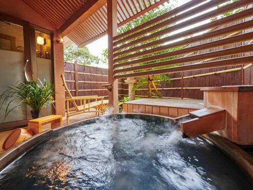 a hot tub in the middle of a patio at Hokuriku Fukui Awara Onsen Mimatsu in Awara