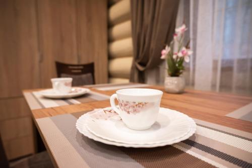 a table with a coffee cup and plates on it at Solva Resort Medical & SPA in Polyana