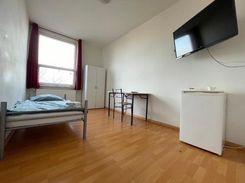 a room with a bed and a television on the wall at GASTEM UG in Berlin
