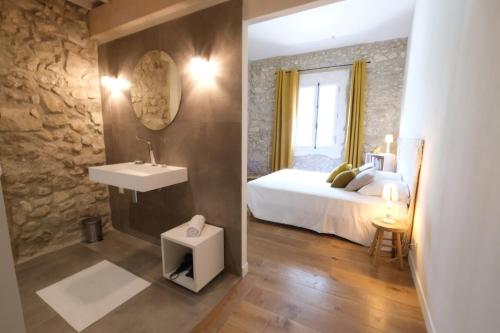 une chambre avec un lit, un lavabo et un miroir dans l'établissement property in les baux de provence, private pool, magnificent view, ideal for 10 people in the alpilles., aux Baux-de-Provence