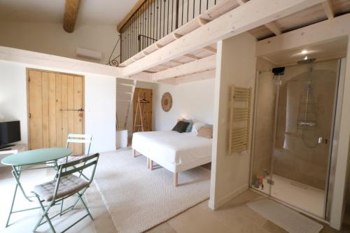 - une chambre avec un lit, une table et une douche dans l'établissement property in les baux de provence, private pool, magnificent view, ideal for 10 people in the alpilles., aux Baux-de-Provence