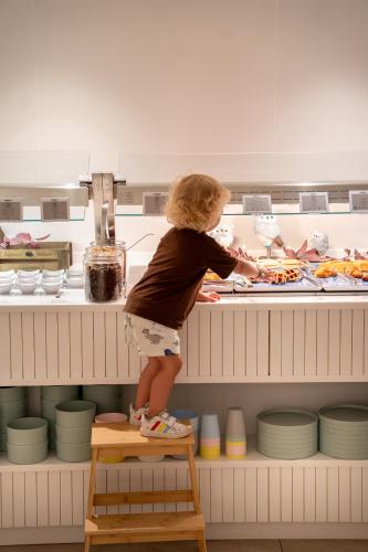 a young child standing on a stool in front of a counter at Iberostar Waves Gaviotas Park in Morro del Jable