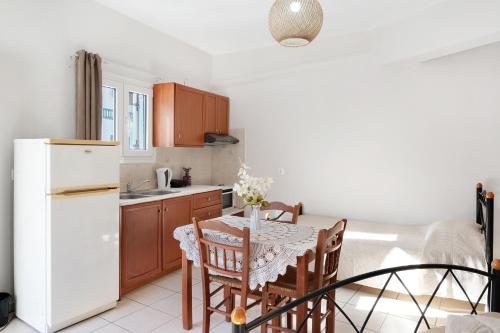 a kitchen with a table and a white refrigerator at Merichas 7 Irida in Mérikhas