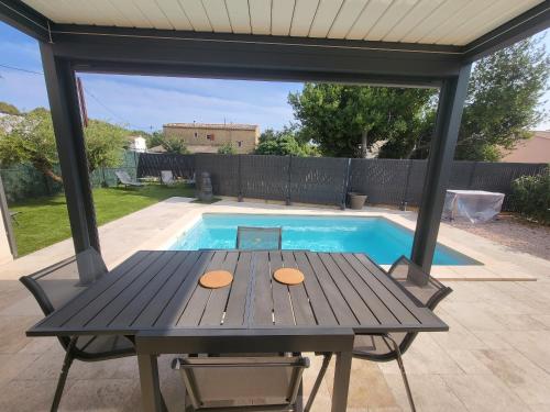 a picnic table in front of a swimming pool at Pleasant detached villa with private swimming pool for 6 people in Lauris - Luberon. in Lauris