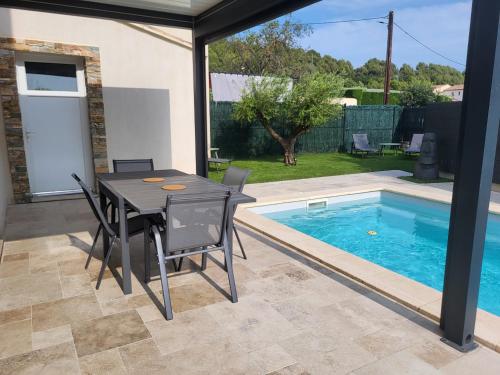 a patio with a table and chairs next to a swimming pool at Pleasant detached villa with private swimming pool for 6 people in Lauris - Luberon. in Lauris