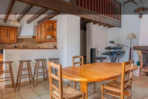 une cuisine avec une table en bois et quelques chaises dans l'établissement Magnifique VILLA Piscine chauffée ouverte Vue Montagne prêt Genêve et Chamonix, à Ville-en-Sallaz