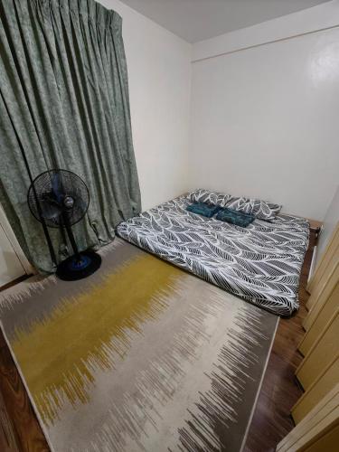 a small bedroom with a bed and a window at Cozy Townhouse own parking Wi-Fi in Baguio
