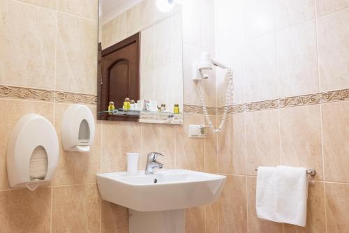 a bathroom with a sink and a mirror at Solva Resort Medical & SPA in Polyana