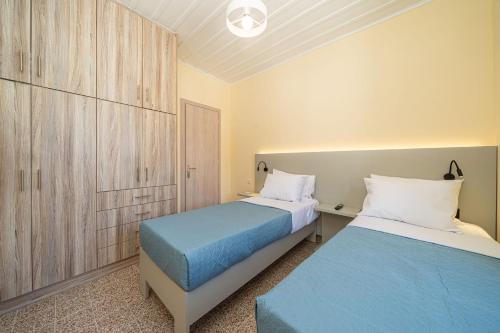 two beds in a small room with a blue bed at Villa Onera in Vlachata