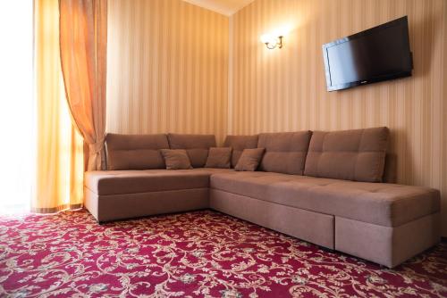 a living room with a couch and a flat screen tv at Solva Resort Medical & SPA in Polyana