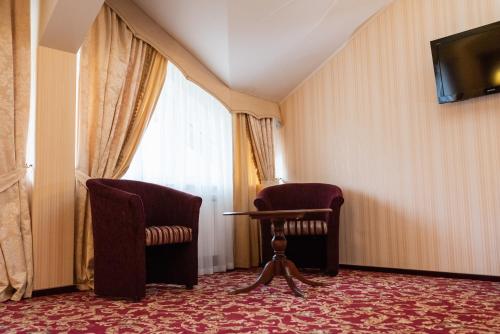 a room with two chairs and a table and a window at Solva Resort Medical & SPA in Polyana
