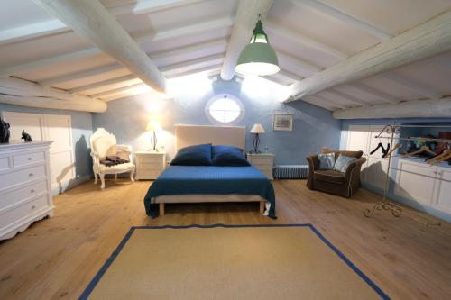 une chambre avec un lit, un canapé et une chaise dans l'établissement typical provençal farm house close to l'isle sur la sorgue - 12 persons, à Cavaillon