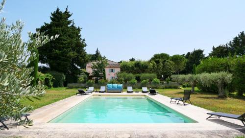 une piscine dans une cour avec des chaises et une maison dans l'établissement typical provençal farm house close to l'isle sur la sorgue - 12 persons, à Cavaillon